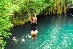 blond girl gliding in zipline at cenote extreme park cancun